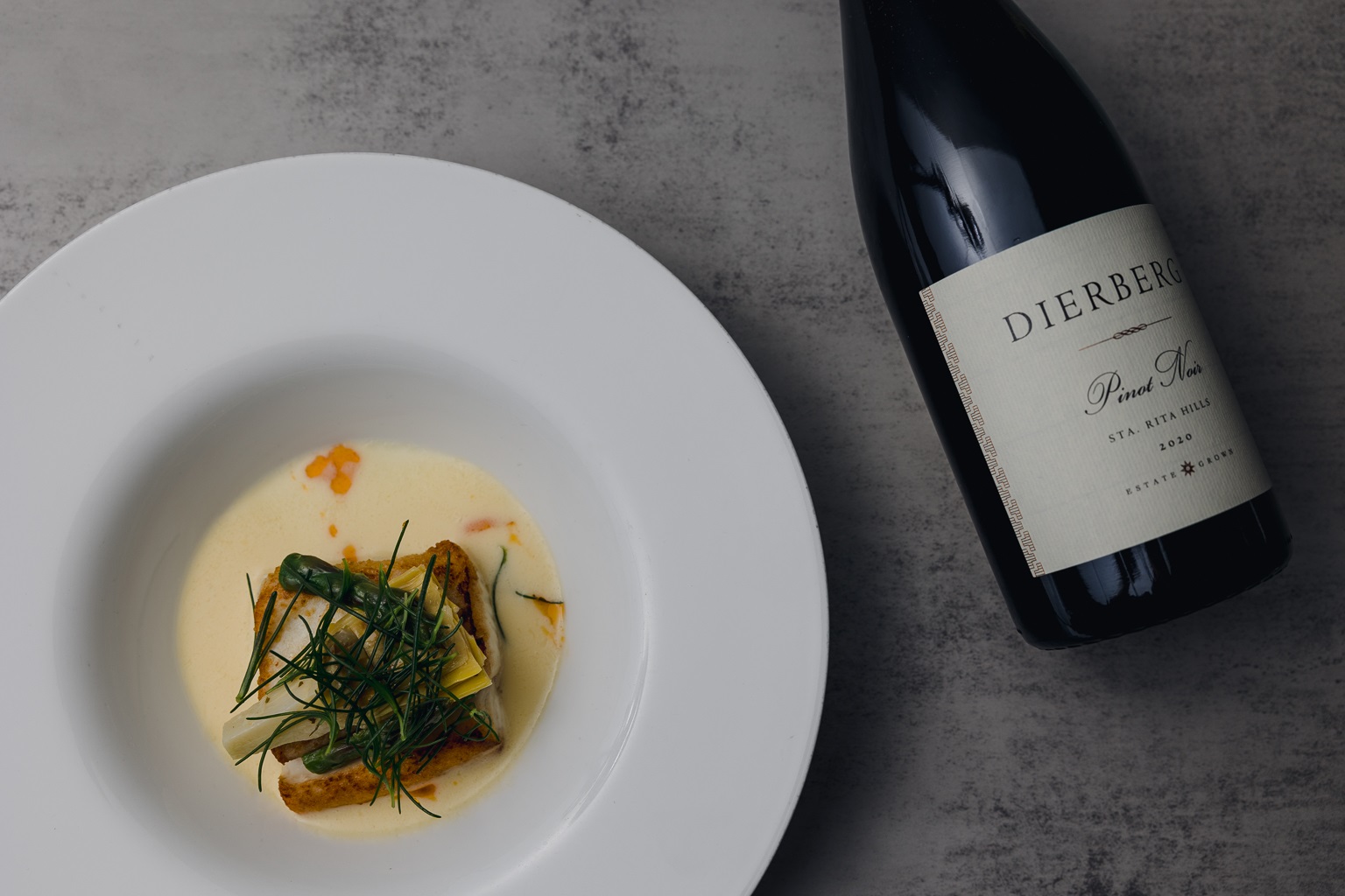 Dierberg Pinot Noir beside a plated dish at a winemaker dinner